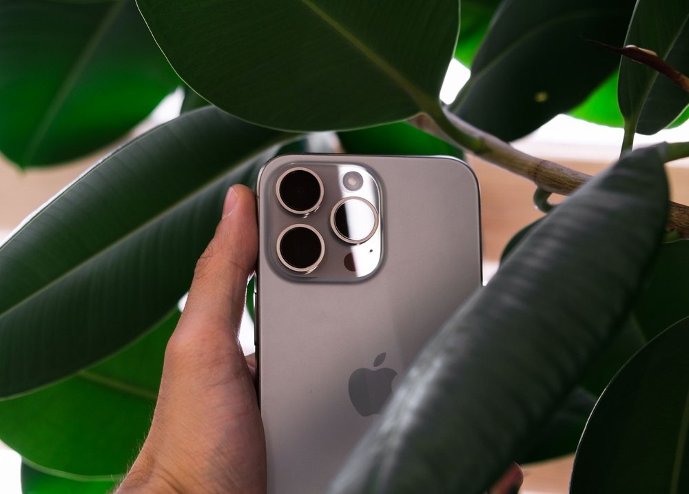 iphone z potrójnym aparatem fotograficznym na tle zieleni
