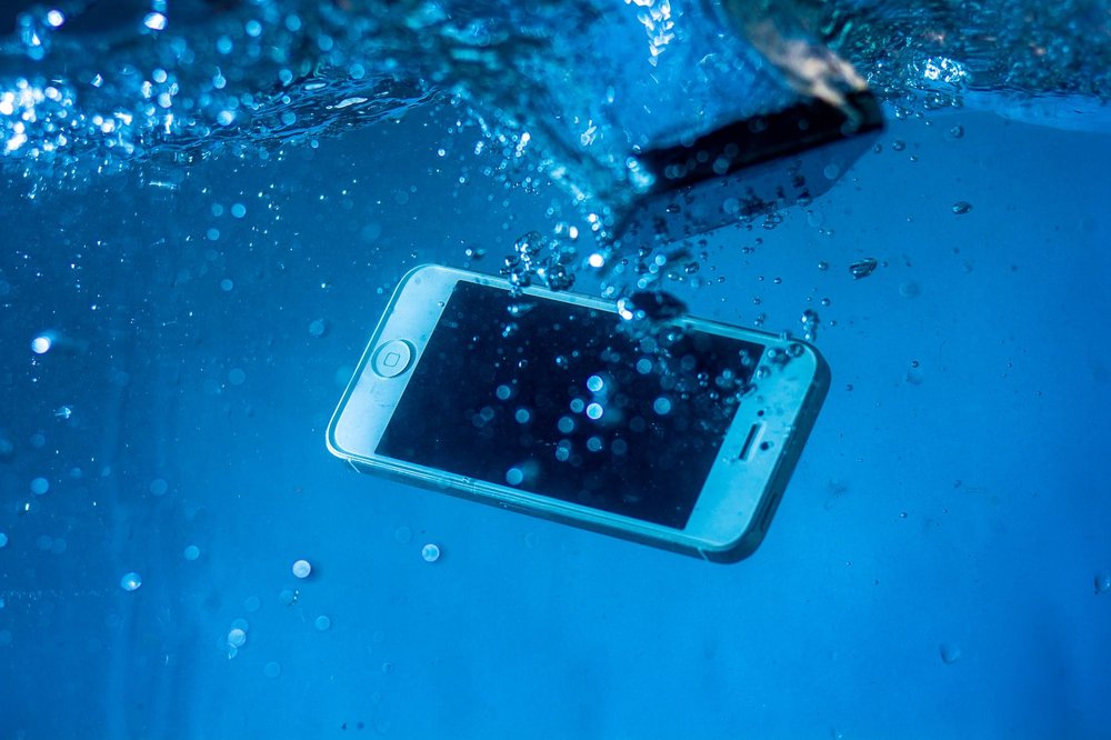 Smartfon zanurzony pod wodą z bąbelkami powietrza