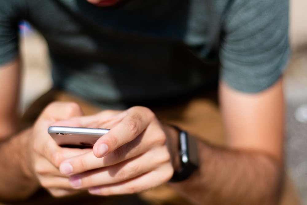 Zbliżenie rąk używających smartfona na świeżym powietrzu