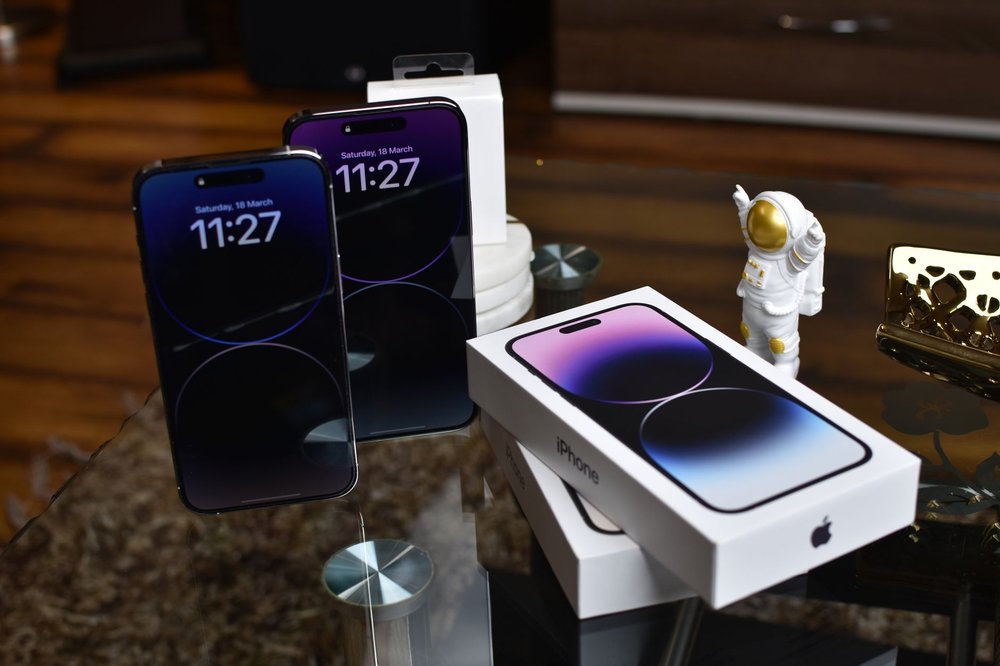 iPhone 14 Pro Max z figurką astronauty na błyszczącej powierzchni