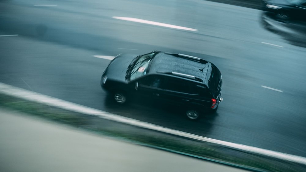 Czarny SUV przyspieszający na mokrej autostradzie, ilustracja prędkości