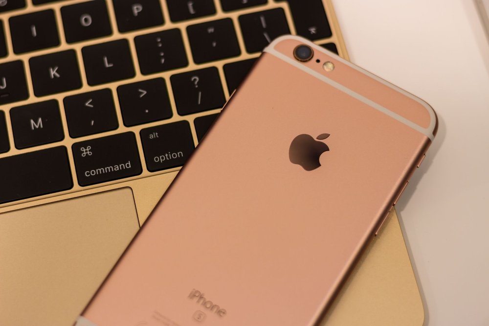 iPhone 6s rose gold leżący na klawiaturze MacBook